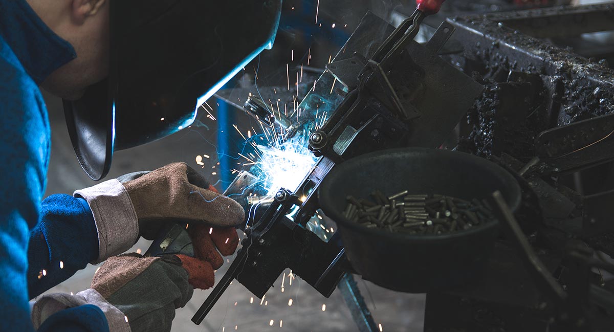 Schweißarbeiten an einer Maschine Arbeiter beim Schweißen an einer maschinellen Anlage