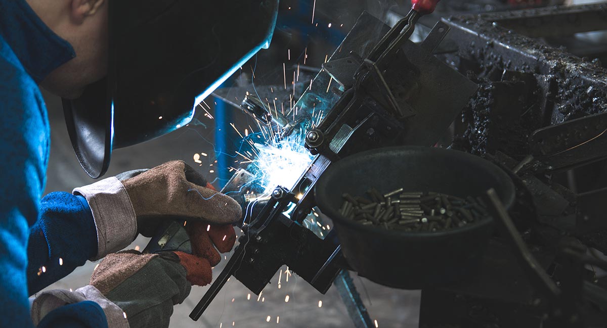 Arbeiter beim Schweißen an einer maschinellen Anlage